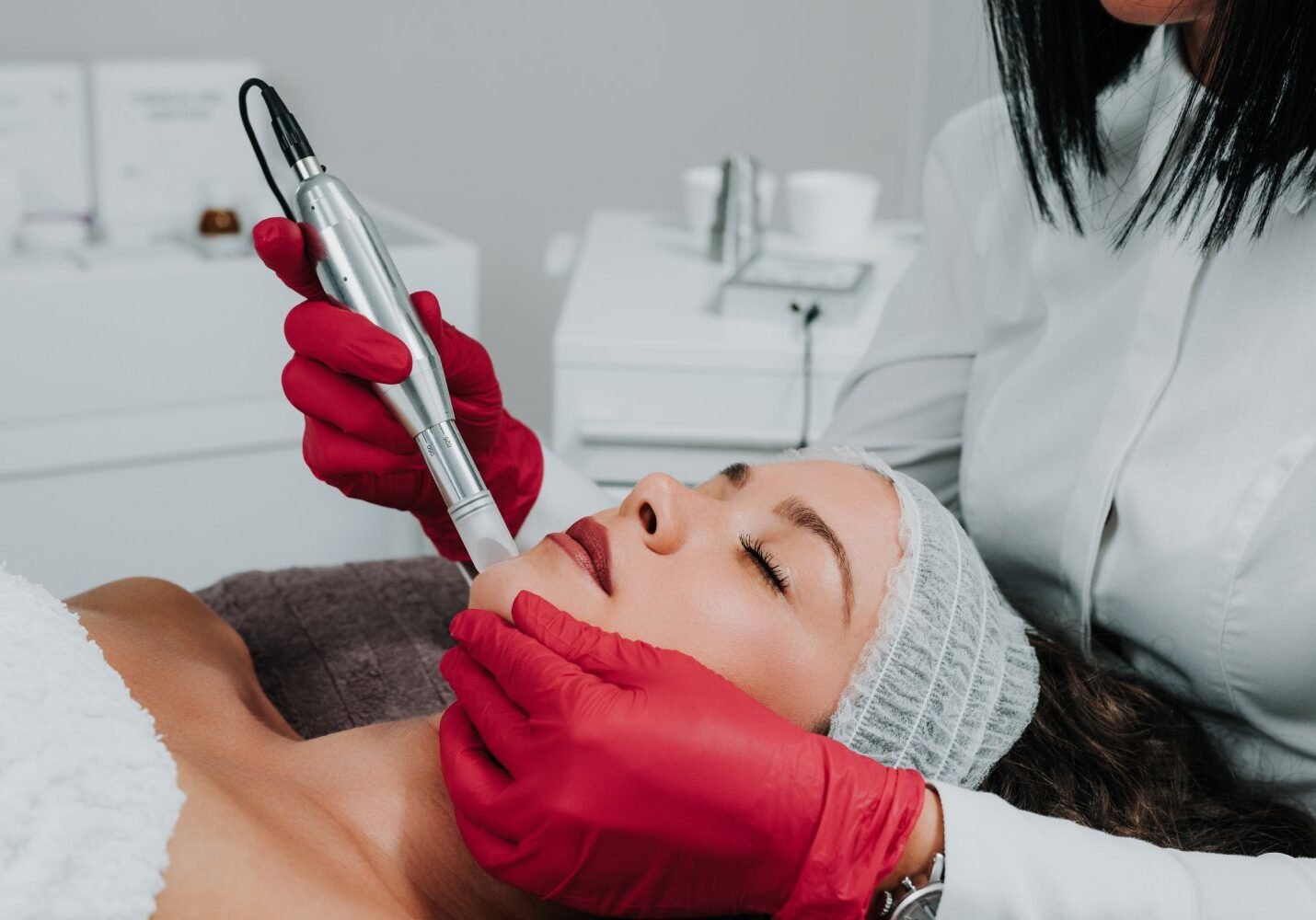 Woman applying a calming serum to freshly treated facial skin at home
